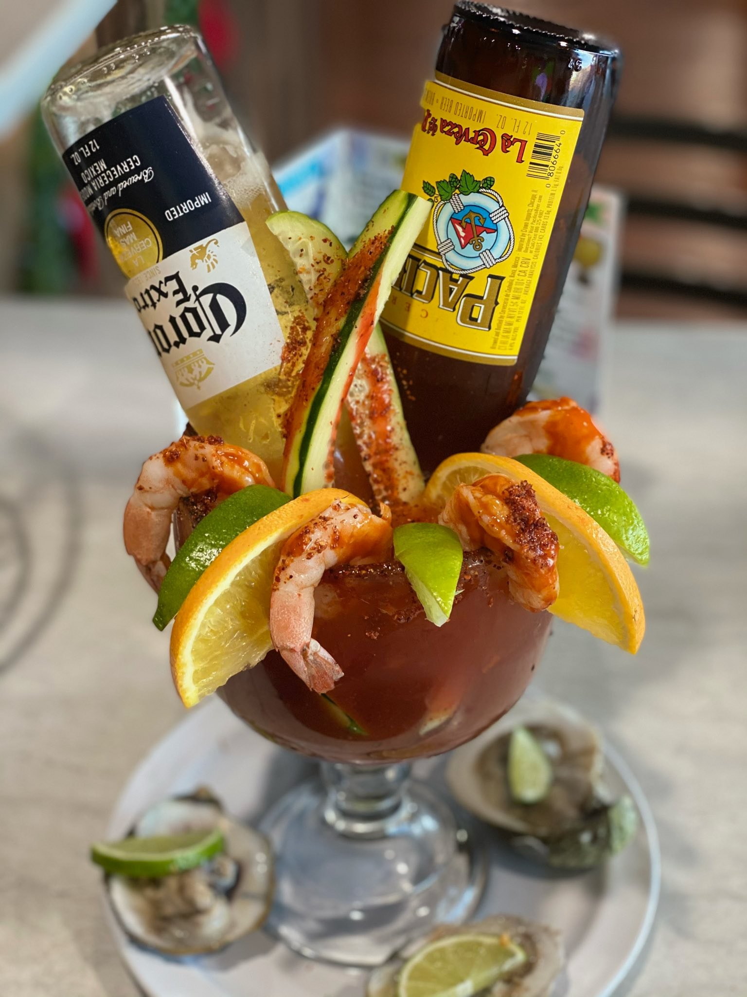 La Morenita’s cocktail with shrimp, citrus, and a beer bottle